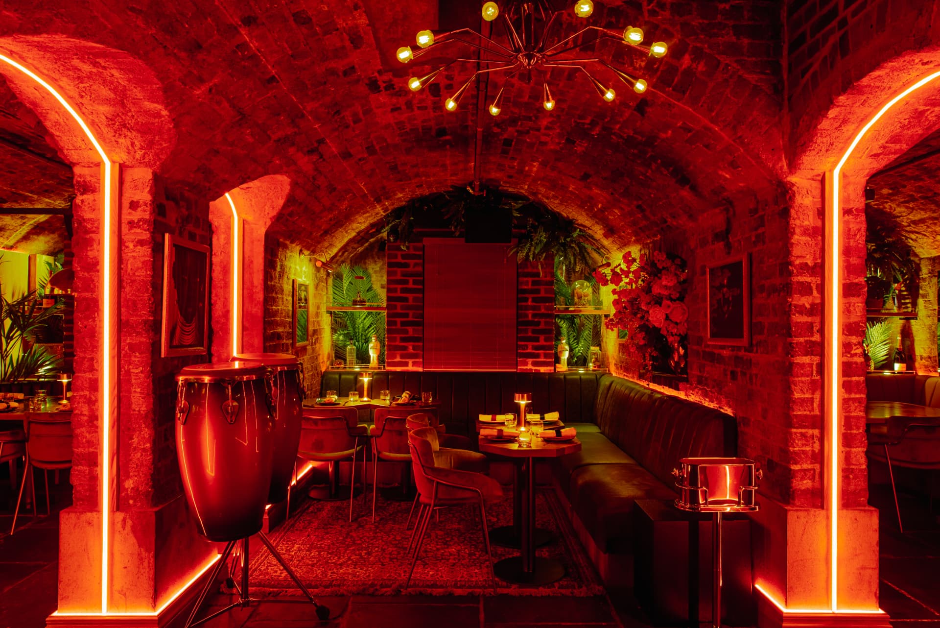 A neon-lit archway leading to a private booth inside the Cache Cache vaults