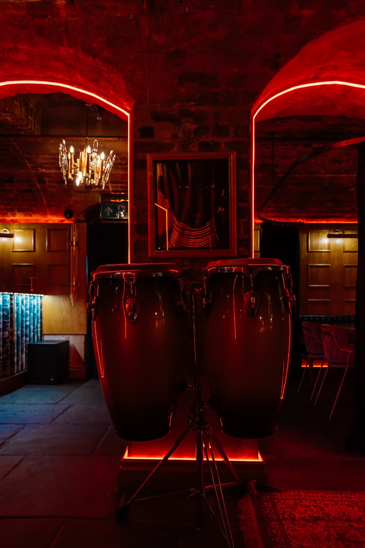 Congas glowing under red light in the Cache Cache vaults