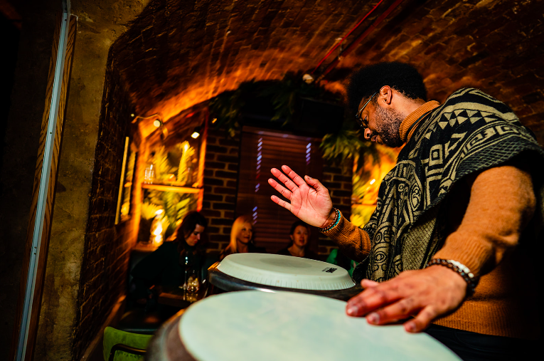 A percussionist playing congas for guests in the candlelit vaults
