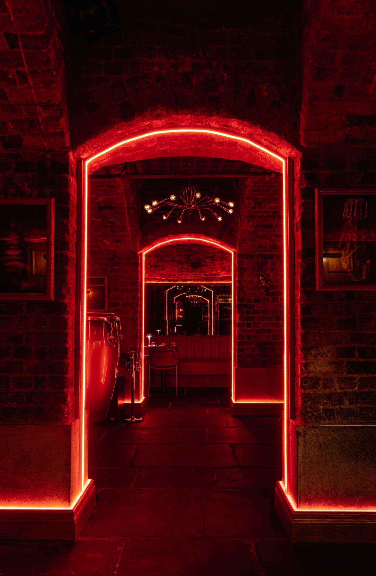 Neon-outlined brick archways leading deeper into the venue